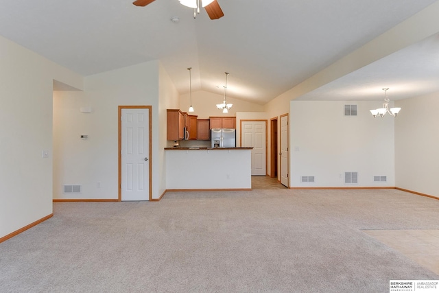 unfurnished living room with ceiling fan with notable chandelier, light colored carpet, and lofted ceiling