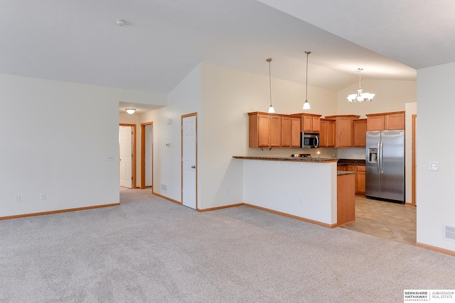 kitchen with stainless steel appliances, kitchen peninsula, an inviting chandelier, light colored carpet, and pendant lighting