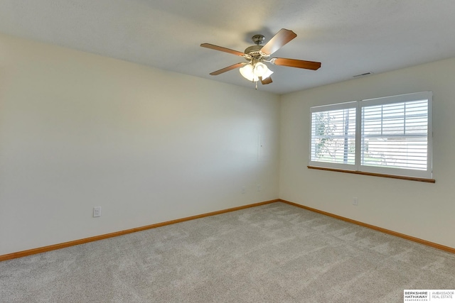 spare room featuring light carpet and ceiling fan