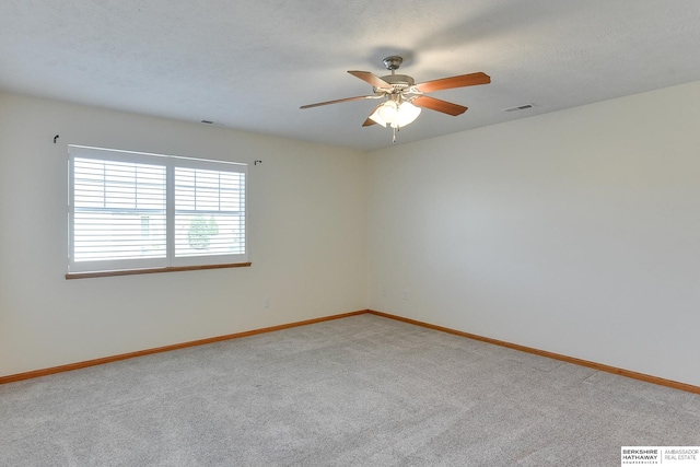 carpeted spare room featuring a textured ceiling and ceiling fan