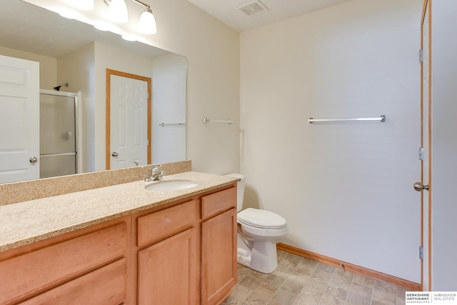 bathroom featuring vanity, toilet, and a shower with shower door