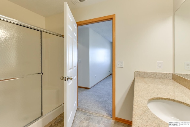 bathroom with vanity and a shower with shower door