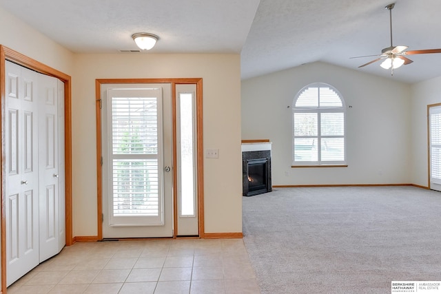 entryway featuring vaulted ceiling, light tile patterned floors, ceiling fan, and a textured ceiling