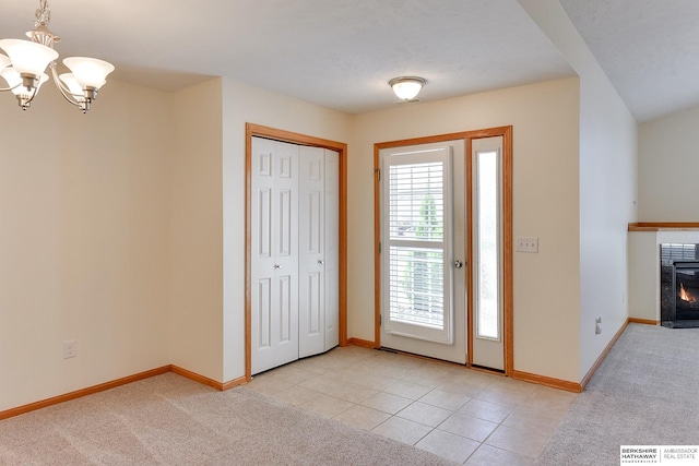 tiled entryway with a notable chandelier