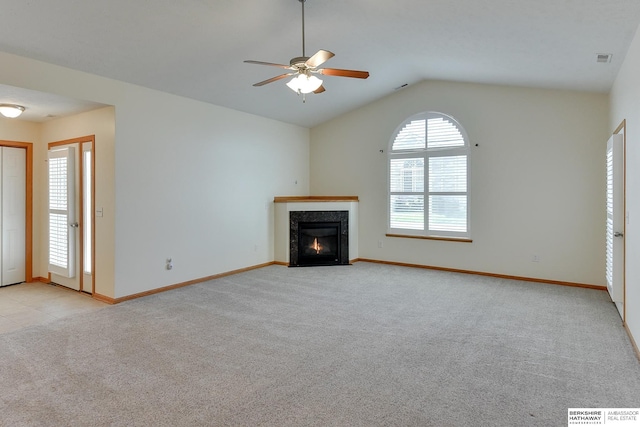 unfurnished living room with ceiling fan, plenty of natural light, lofted ceiling, and light colored carpet