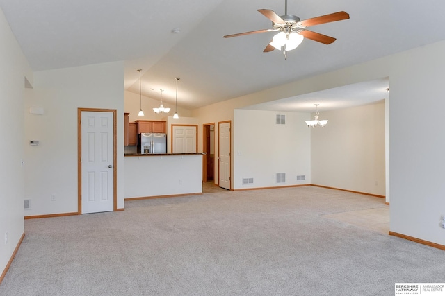 unfurnished living room featuring high vaulted ceiling, light carpet, and ceiling fan with notable chandelier