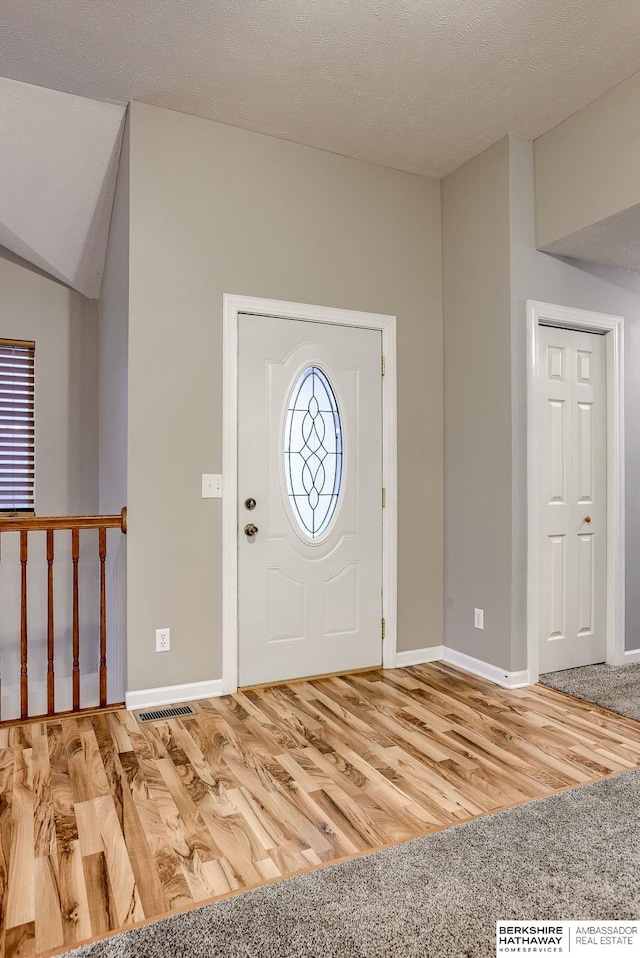 foyer with hardwood / wood-style floors and a textured ceiling