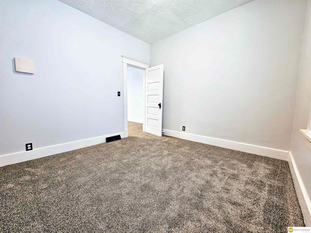 carpeted spare room with a textured ceiling