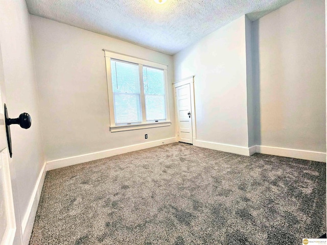 carpeted empty room featuring a textured ceiling