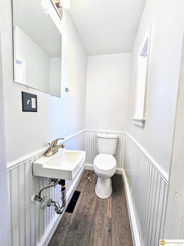 bathroom with hardwood / wood-style floors, toilet, and sink