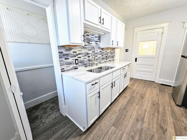 kitchen featuring dark hardwood / wood-style floors, white cabinetry, and sink