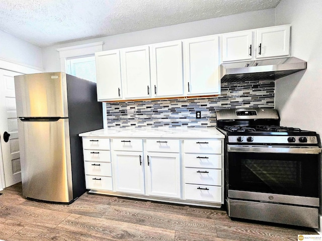 kitchen with white cabinetry, stainless steel appliances, and hardwood / wood-style flooring