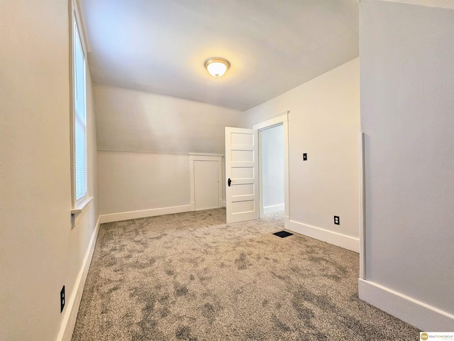 additional living space with carpet and vaulted ceiling