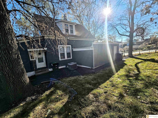 back of property featuring a lawn and cooling unit