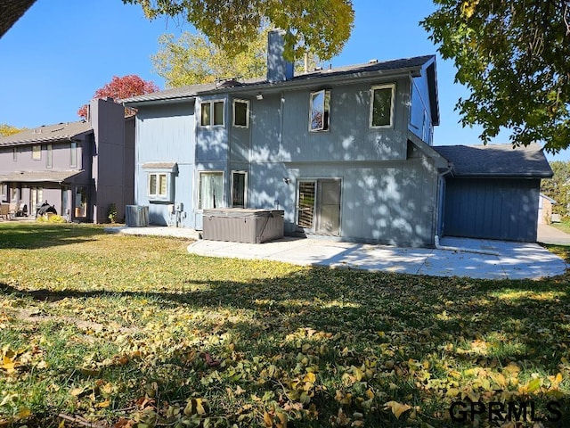 back of house featuring a hot tub, a yard, and a patio