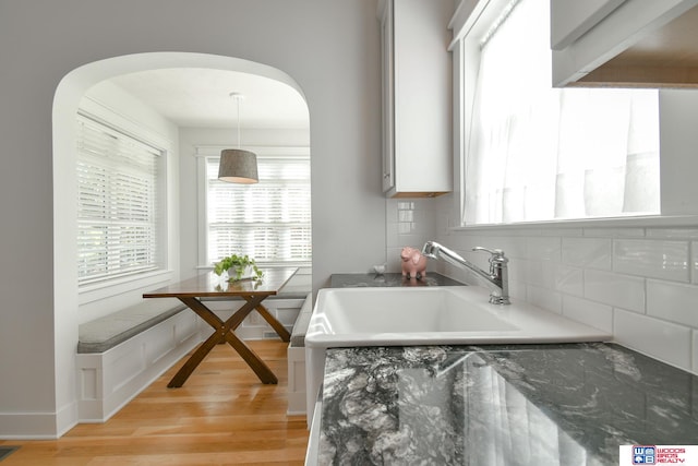 kitchen with light hardwood / wood-style flooring, tasteful backsplash, and hanging light fixtures