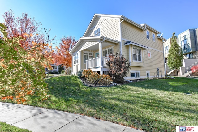 view of side of home featuring a yard and covered porch