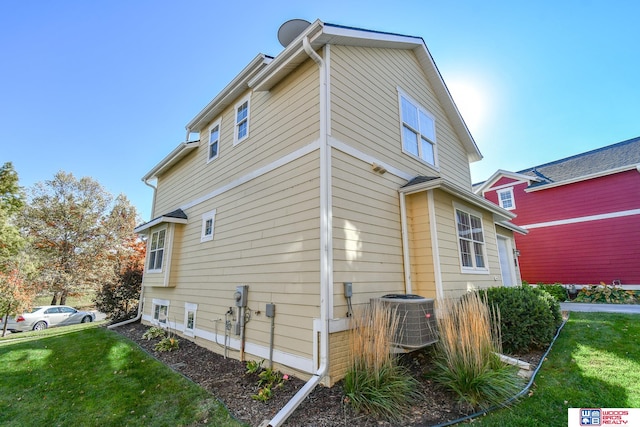 view of side of property featuring a yard and central AC unit