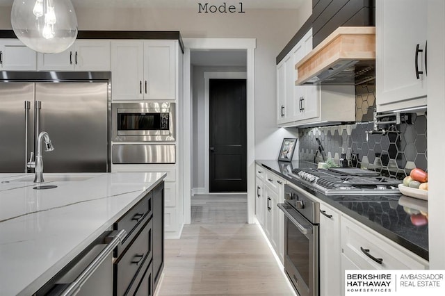 3902 S 212th St, Omaha, NE 68022 - kitchen with built in appliances, a warming drawer, premium range hood, decorative backsplash, and white cabinetry