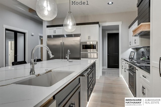 3902 S 212th St, Omaha, NE 68022 - kitchen with built in appliances, a sink, a warming drawer, decorative light fixtures, and light stone counters