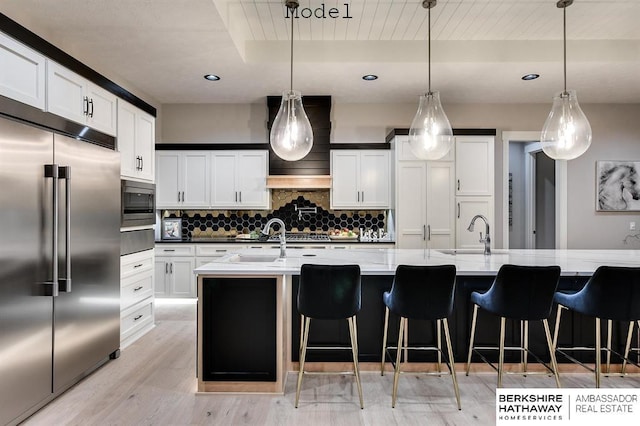 3902 S 212th St, Omaha, NE 68022 - kitchen featuring built in appliances, backsplash, a warming drawer, light wood finished floors, and a breakfast bar