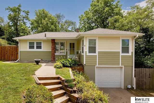 view of front of home with a front yard and a garage