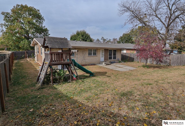 back of property with a patio area, a playground, and a yard