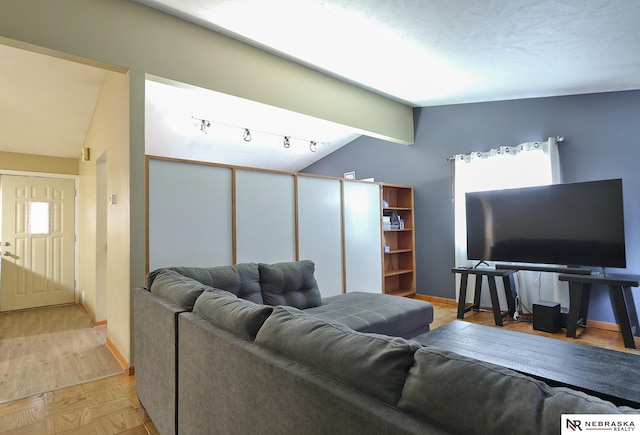 living room with vaulted ceiling with beams and light parquet floors