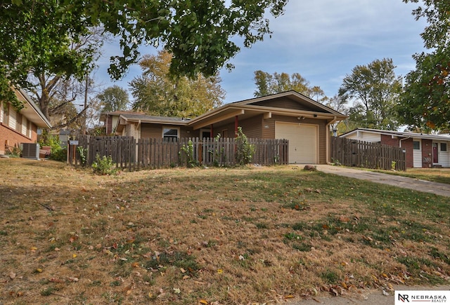 ranch-style house featuring a front yard, a garage, and central AC unit