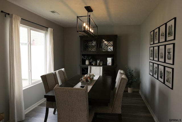 dining area with an inviting chandelier and dark hardwood / wood-style floors