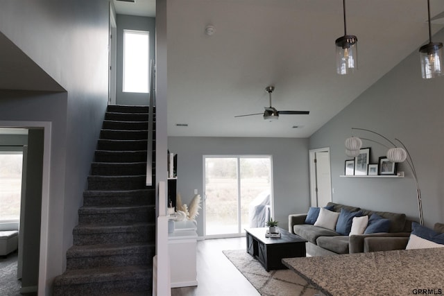 carpeted living room featuring vaulted ceiling and ceiling fan