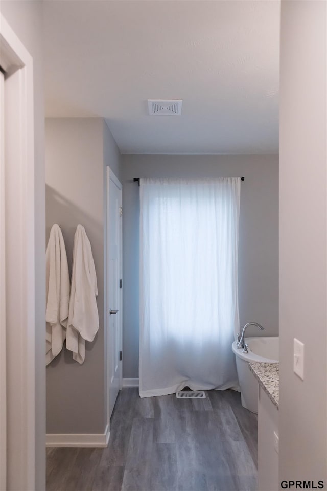 bathroom with hardwood / wood-style floors and a washtub