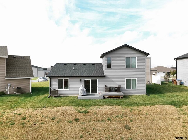 rear view of property featuring a wooden deck, a lawn, and central AC unit