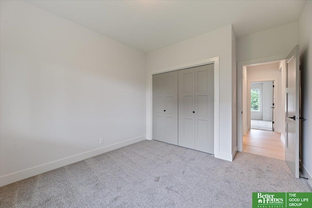 unfurnished bedroom with light carpet and a closet