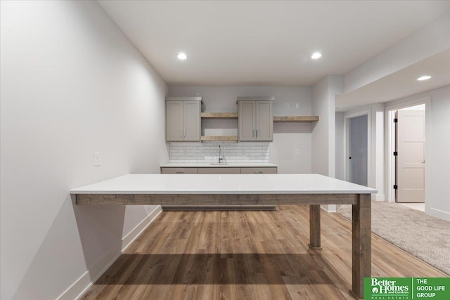 kitchen with tasteful backsplash, dark hardwood / wood-style floors, sink, and gray cabinetry