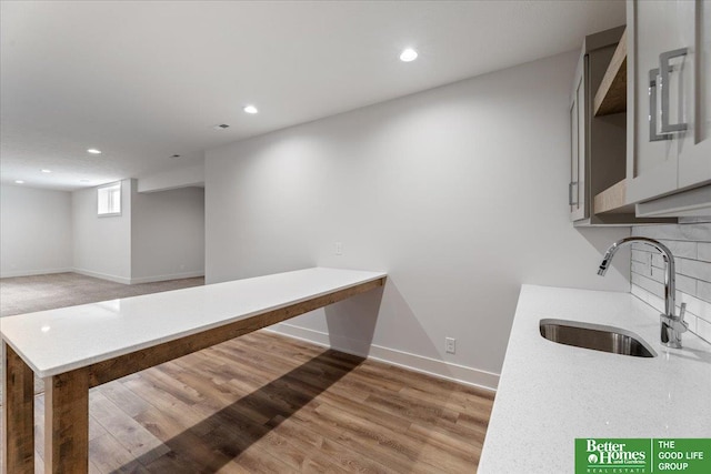 kitchen featuring hardwood / wood-style floors, sink, and decorative backsplash