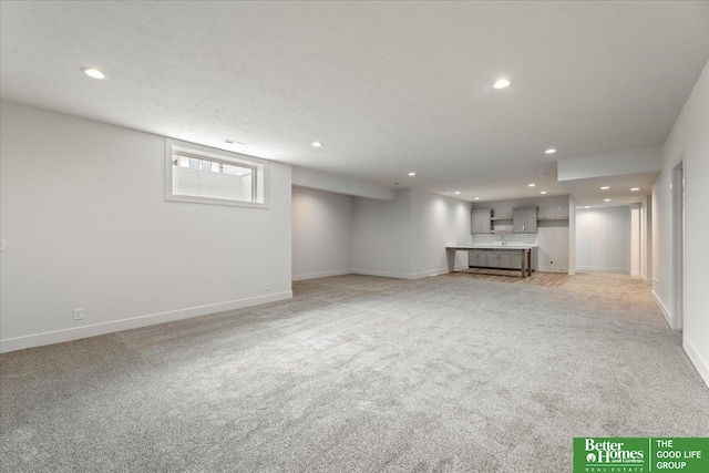 interior space featuring light colored carpet and a textured ceiling