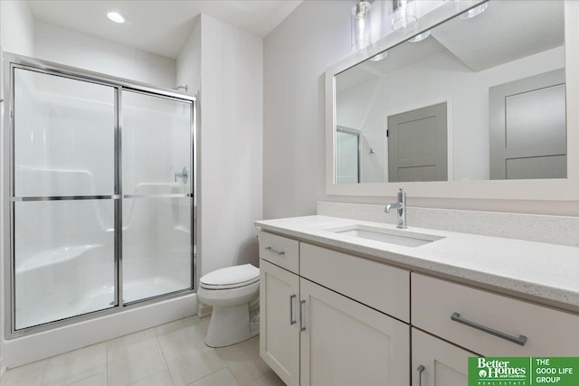 bathroom featuring toilet, vanity, tile patterned flooring, and a shower with door