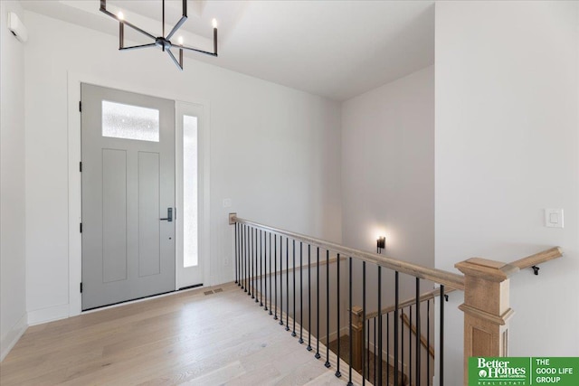 entrance foyer with light hardwood / wood-style floors and an inviting chandelier