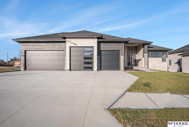 prairie-style home featuring a garage and a front yard