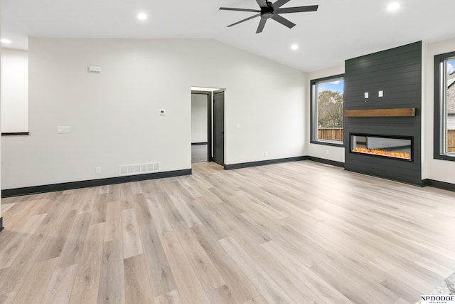 unfurnished living room featuring a fireplace, ceiling fan, light hardwood / wood-style flooring, and vaulted ceiling