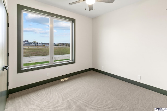 empty room with carpet, plenty of natural light, and ceiling fan