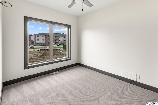 carpeted spare room with ceiling fan