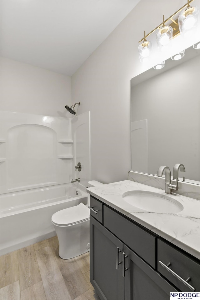 full bathroom featuring shower / washtub combination, vanity, hardwood / wood-style flooring, and toilet