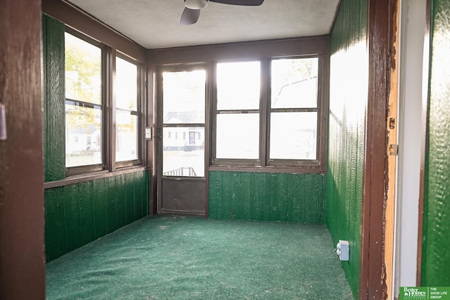 unfurnished sunroom featuring a wealth of natural light and ceiling fan