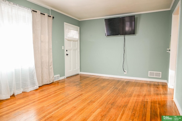 spare room with wood-type flooring and crown molding