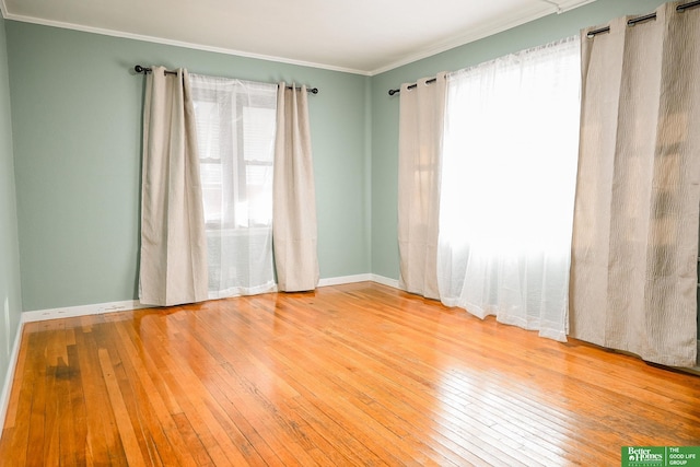 spare room featuring hardwood / wood-style flooring and ornamental molding