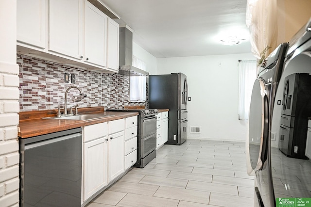 kitchen with white cabinetry, wall chimney range hood, sink, and stainless steel appliances