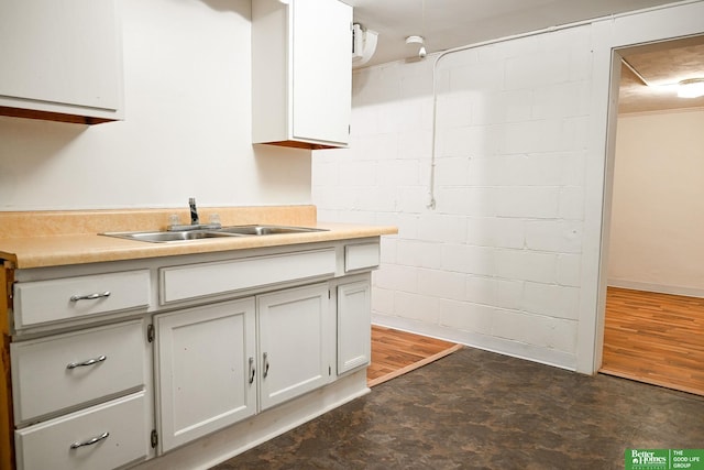 kitchen with dark hardwood / wood-style floors, white cabinetry, and sink