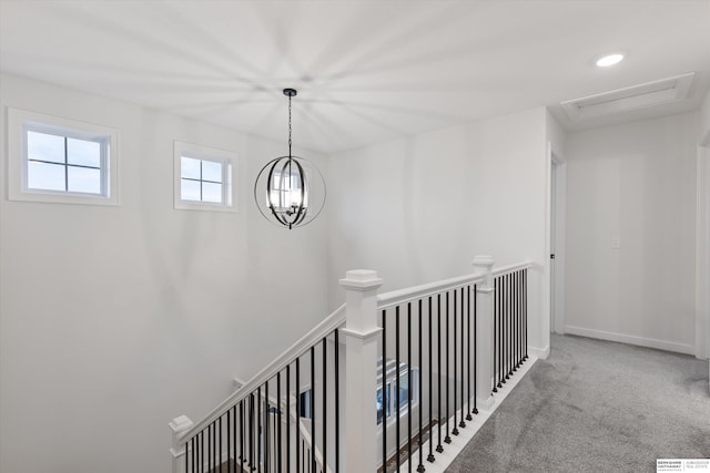 corridor featuring carpet and a notable chandelier